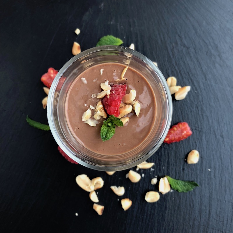 Chocolate Peanutbutter Mousse, vegan, plantbased, shot from top with raspberry on black background