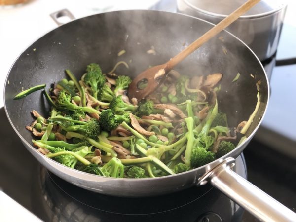 Verduras verdes salteados en un wok