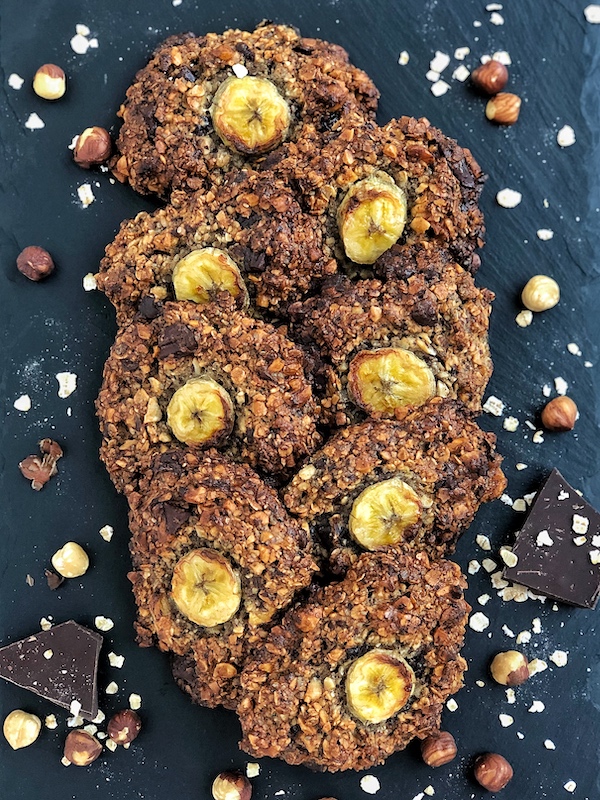 Vegan Chocolate-Chip-Banana-Oatmeal Cookies with Hazelnuts on black slate