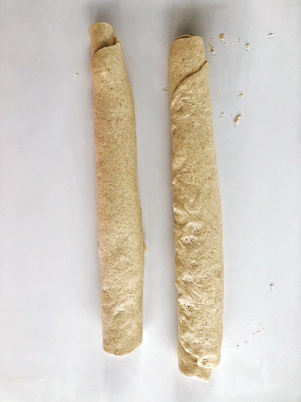 Raw dough rolls of vegan twisted pesto bread
