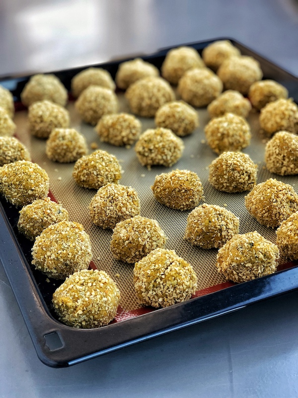 Vegan falafel balls, on a baking tray ready for the oven