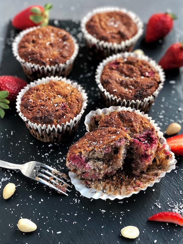 Vegan Berry Muffins with a Cashew-Date-Caramel filling on a black slate and fork