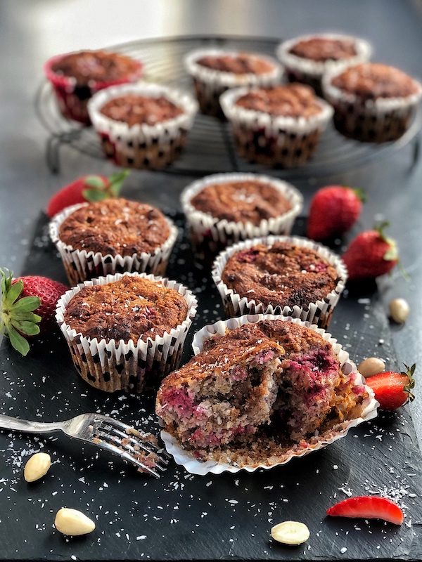 muffins veganos de frambuesa con coco y con un centro cremoso de caramelo de dátiles y anacardos veganos encima de pizarra negra