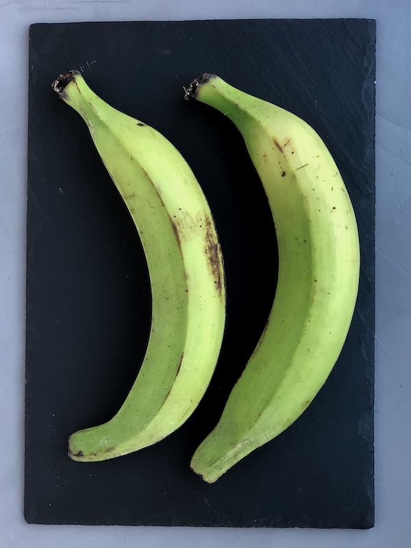 Plátanos verdes (macho) encima de pizarra negra